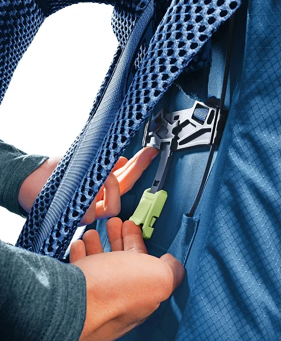 Nahaufnahme einer Hand, die den Zipper eines blauen Deuter-Rucksacks öffnet. Sichtbar sind Netzgewebe und Befestigungsclips.